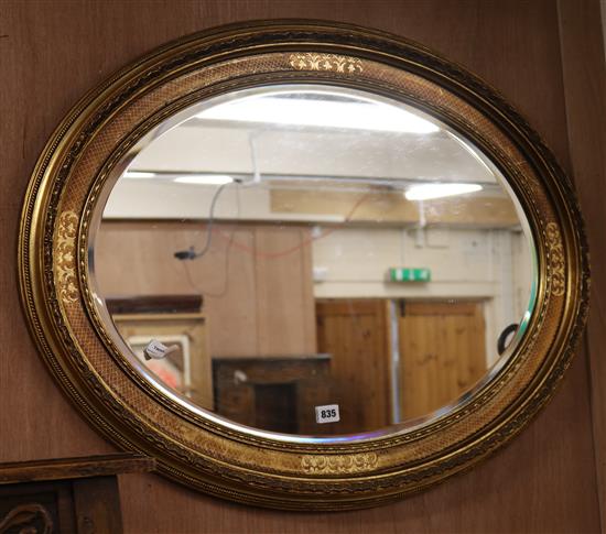 An oval gilt-framed wall mirror W.87cm
